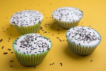 Vanilla cup cake with white icing and candies on top