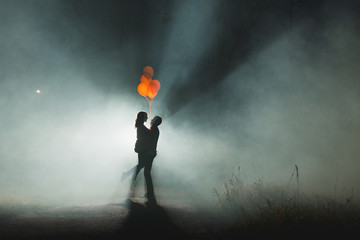 portrait of the happy couple on the beach, river or lake. Cloudy autumn, but they came to the...