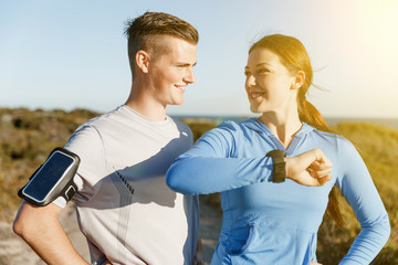 Runner woman with heart rate monitor running on beach