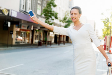 Business woman pulling suitcase bag walking in city