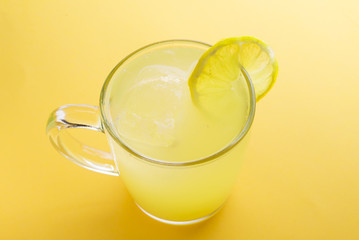 Water and lemon in yellow background