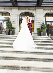 Beautiful bride and groom embracing  on their wedding day outdoors