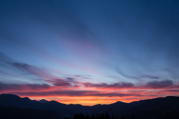Fototapeta premium Colorful beautiful sunset over the mountain hills