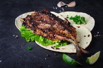 Baked spicy mackerel with flatbread on dark stone backgrond. 