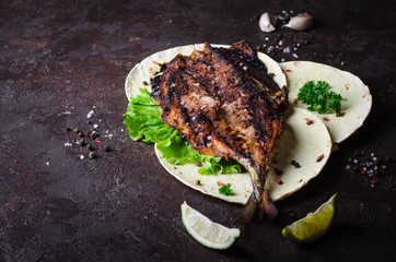 Baked spicy mackerel with flatbread on dark stone backgrond. 