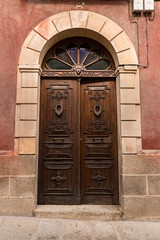 Puerta antigua de madera con arco de piedra.