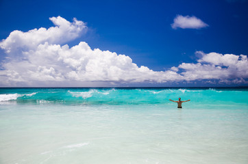 Fototapeta na wymiar Tropical beach, man enjoy turquoise waves of ocean