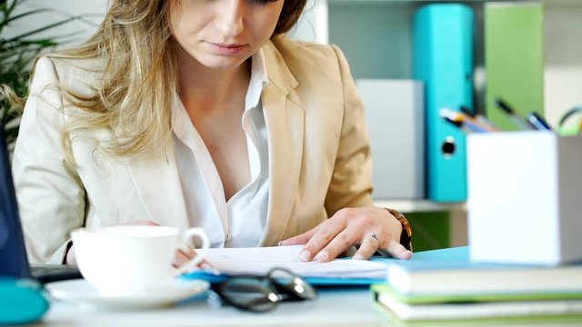 Businesswoman sitting in the office and having a paperwork, steadycam shot
