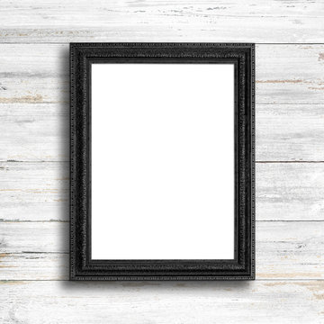 Black picture frame on white wood wall.