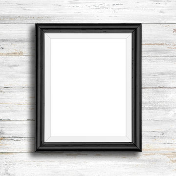 Black picture frame on white wood wall.