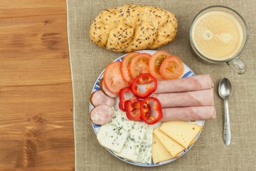 Breakfast on the table. Ham, tomato and cheese for breakfast with bread. Homemade healthy food. Vegetables and ham for breakfast.
