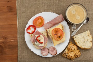 Breakfast on the table. Ham, tomato and cheese for breakfast with bread. Homemade healthy food. Vegetables and ham for breakfast.
