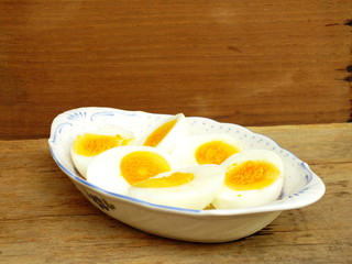 boiled eggs on plate and wooden background close up