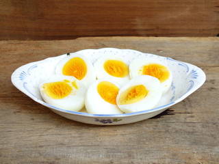 boiled eggs on plate and wooden background close up
