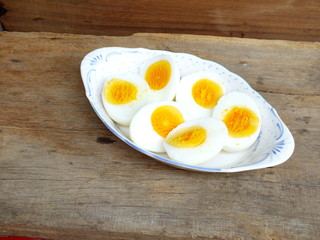 boiled eggs on plate and wooden background close up
