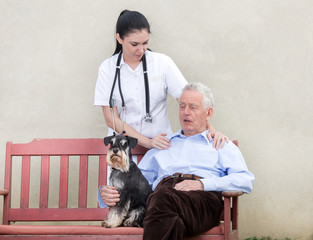 Senior man with caregiver and dog
