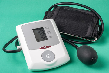 automatic blood pressure monitor on a green background