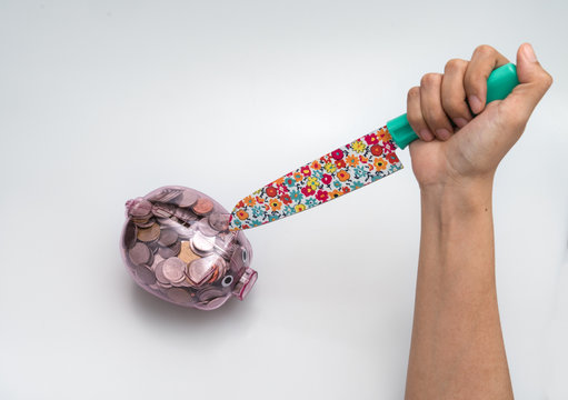 hand hold knife with see through piggy bank pink with money coin