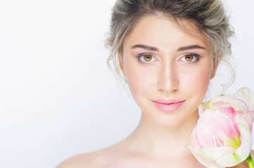 Naklejka premium Young beautiful woman with healthy face and nude makeup posing with delicate pink flower on white background