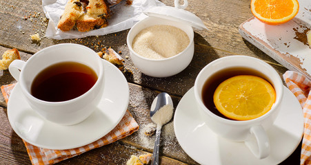 Two Cups of tea with cake and orange
