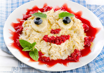 Smiling oatmeal and fresh berries for a healthy breakfast.