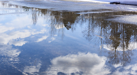 Reflection of clouds in puddle
