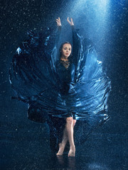 The young beautiful modern dancer dancing under water drops