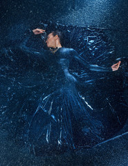 Fototapeta na wymiar The young beautiful modern dancer dancing under water drops