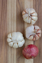 Artistic onion and garlic on wooden table.