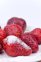 Sugar on the fresh strawberries on the plate
