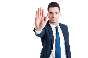 Handsome sales man showing stop or stay gesture