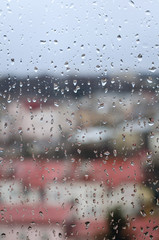City view through a window with rain drops