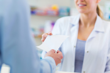 Customer giving prescription to pharmacist - obrazy, fototapety, plakaty