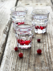 Homemade cranberry vodka, wooden background