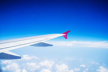 View from airplane window with blue sky and white clouds