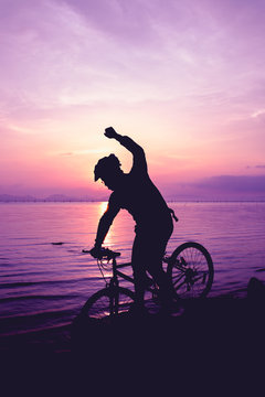 Healthy lifestyle. Silhouette of bicyclist riding the bike at seaside.