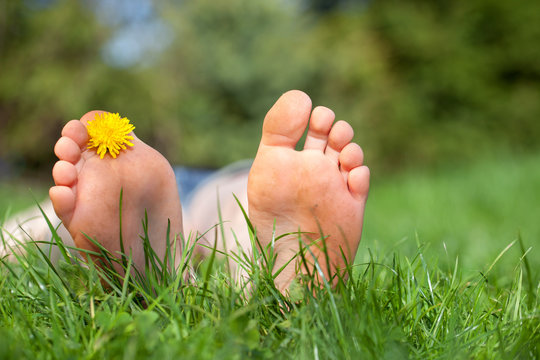 Relax in the garden, flowers feet on green grass
