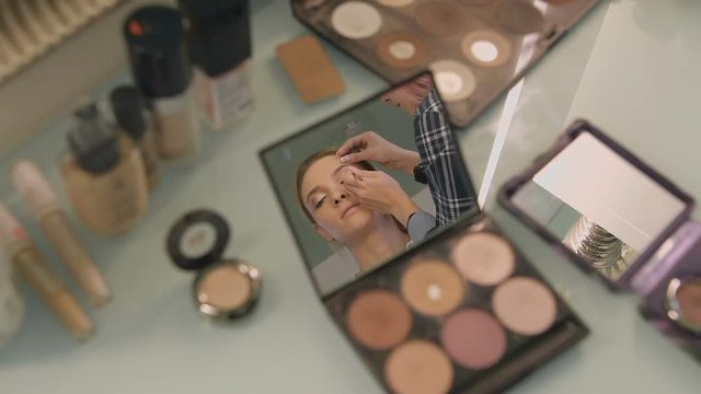 Desk in a beauty salon. reflected in the mirror of her compact face of the girl. Professional Stylist