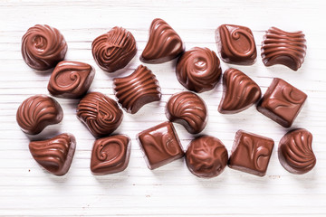 Delicious chocolate candies on wooden background