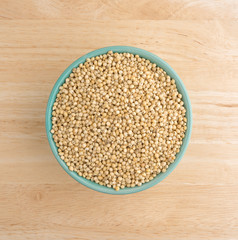 Whole grain sorghum seeds in a bowl on a table.