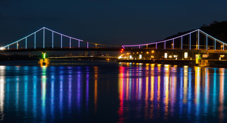 Fototapeta na wymiar Lights night city and bridge with reflections on the river