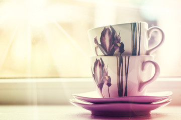  tea set, a bouquet of spring flowers  near  the window