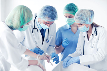 young group of doctors doing operation