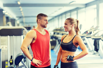 Fototapeta na wymiar smiling man and woman talking in gym
