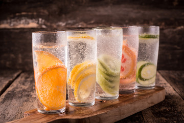 Vitamin water with fruits, refreshment cold drink on wooden background
