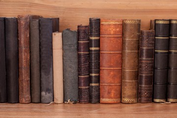 Old books on a wooden shelf. 