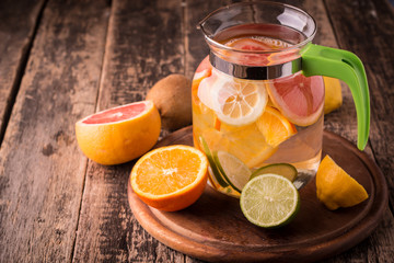 Vitamin water with fruits, refreshment cold drink on wooden background