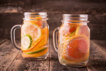 Vitamin water with fruits, refreshment cold drink on wooden background