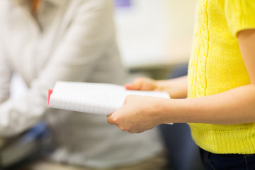 Obraz premium close up of girl with notebook at school lesson