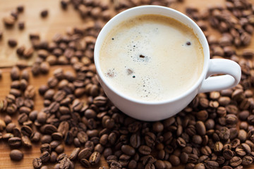 close up coffee cup and grains on wooden table